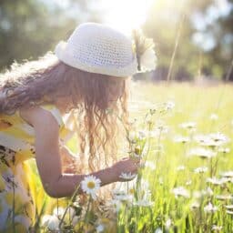 Little girl playing in the wild flowers.