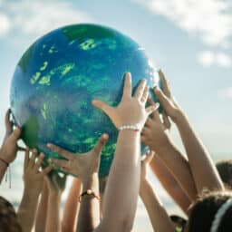 Group of people holding up a large globe