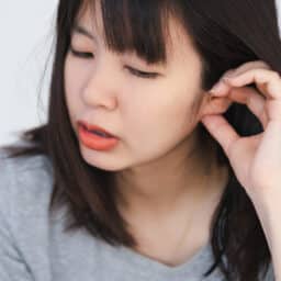 Woman scratches ears